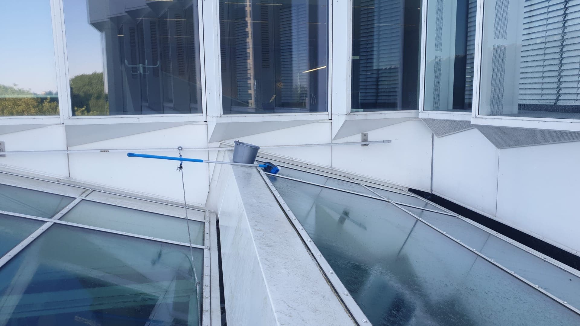 Glazen dakpanelen op een pand in Apeldoorn worden met wasborstel en osmosewater streepvrij gereinigd