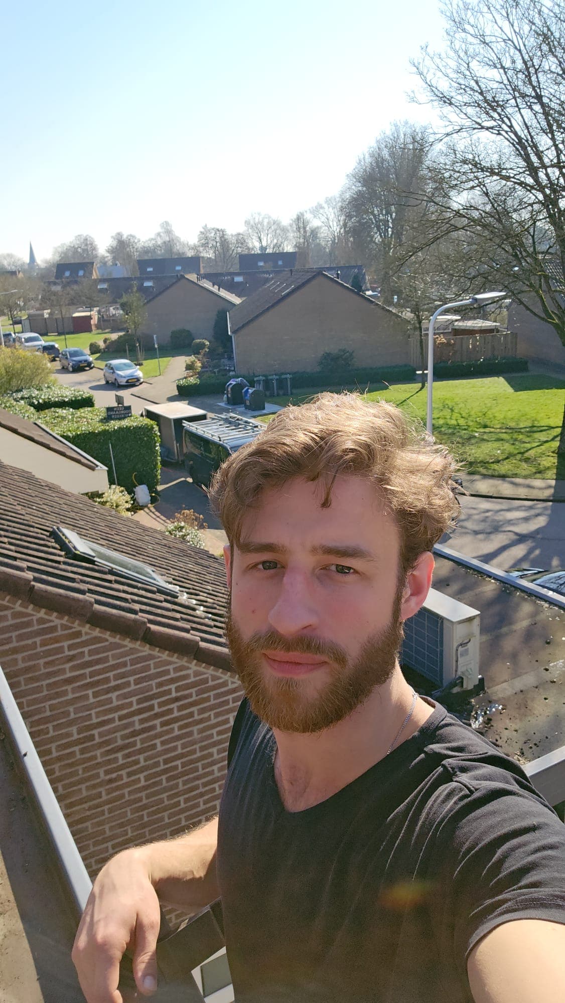 Michael van Madern Glazenwassers op hoogte bij een woning in Apeldoorn, met de bedrijfsbus en ladders op de achtergrond