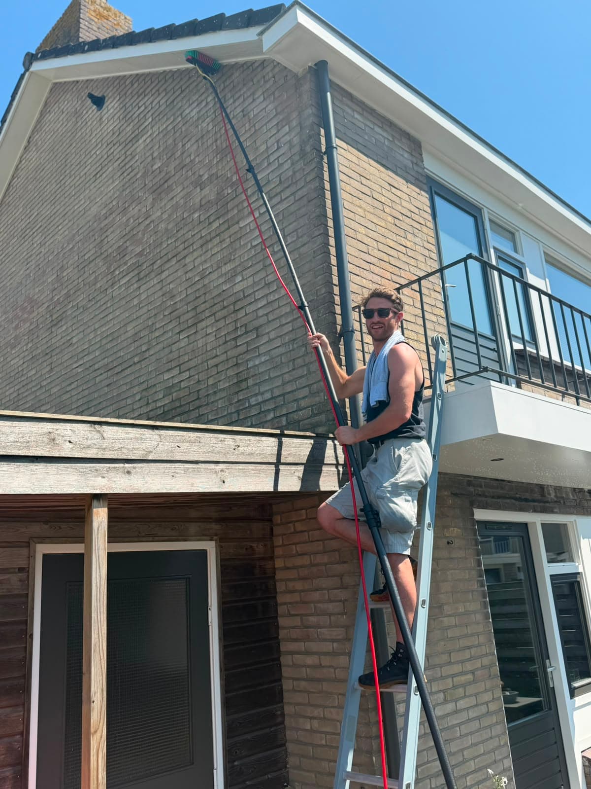 Glazenwasser aan het werk bij een woning in Apeldoorn met een watergevoede telescoopsteel op een ladder