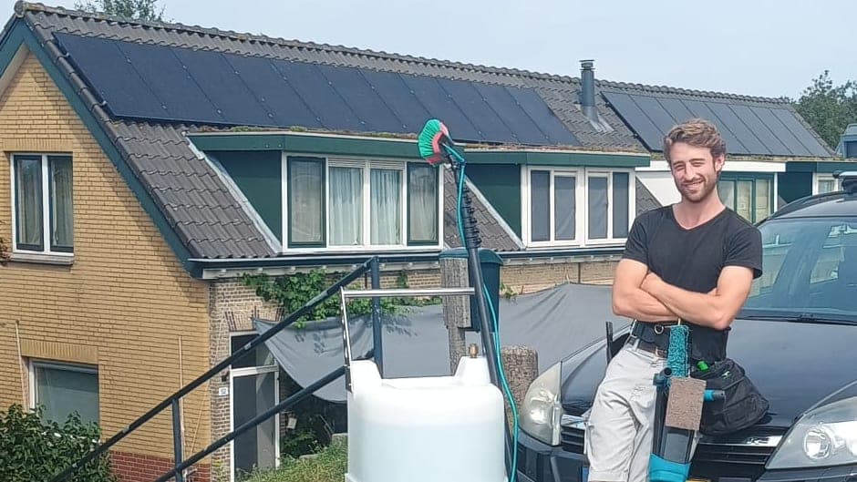 Dak vol zonnepanelen in de omgeving van Apeldoorn, met op de voorgrond de glazenwasser van Madern met borstel en watertank